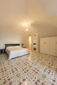 een slaapkamer met een wit bed en een bloemetjestapijt bij San Martino in Ravello