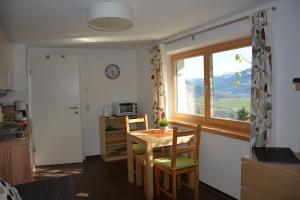 a kitchen with a table and chairs and a window at KirchnerKitz in Piesendorf