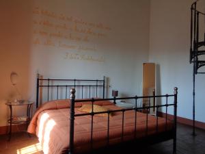 a bedroom with a bed with a writing on the wall at Agriturismo Podere Sant' Antonio in Alberese