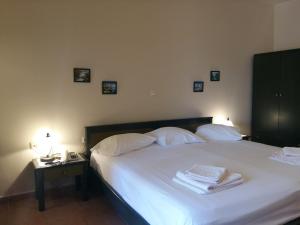 1 dormitorio con 1 cama con sábanas y almohadas blancas en Kallicrates Village, en Frangokastello