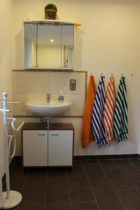 ein Badezimmer mit einem Waschbecken, einem Spiegel und Handtüchern in der Unterkunft Fewo Bemmann in Deisfeld