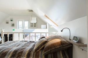 een slaapkamer met een bed in een witte kamer bij Studio Apartment Alba in La Hulpe