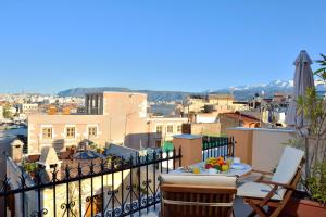 a balcony with a table and chairs and a view of a city at Silde Studios & Apartments in Chania Town