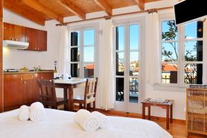 a room with two beds and a kitchen with windows at Silde Studios & Apartments in Chania Town