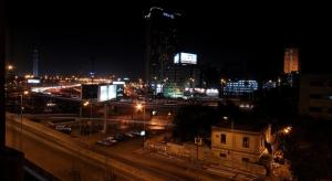 une ville la nuit avec des voitures garées dans un parking dans l'établissement Arabesque Hotel, au Caire