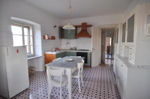 uma cozinha com uma mesa e um frigorífico branco em Panorama em Aurisina