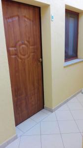 Una puerta de madera en una habitación con suelo de baldosa. en Sa Mamma e Sole B&B, en Cala Gonone