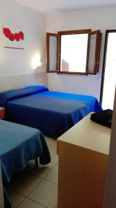 Habitación con 2 camas y ventana en Sa Mamma e Sole B&B, en Cala Gonone
