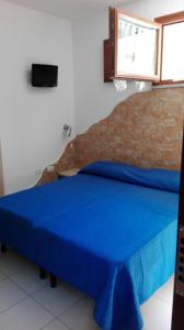 1 dormitorio con 1 cama con colcha azul en Sa Mamma e Sole B&B, en Cala Gonone