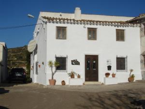a white house with a tree in front of it at Almond Reef Casa Rural in Los Alias
