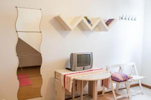 um quarto com uma secretária, uma televisão e uma mesa em Casa de Hóspedes Porto Pim em Horta