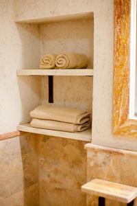 uma casa de banho com prateleiras com toalhas e uma janela em Medin di Lastua em Petrovac na Moru