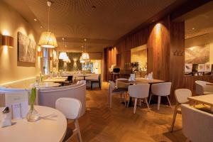 un comedor con mesas y sillas y un restaurante en Ebner - Boutique-Hotel & Konditorei, en Lindau