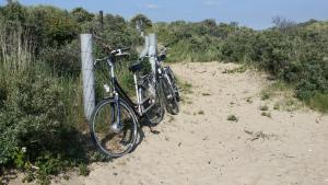 two bikes chained to a fence on a beach at Appartement Bos en Duin in Vogelenzang