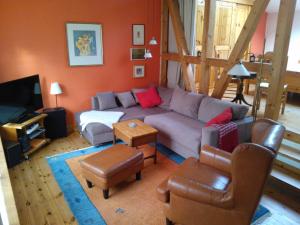 ein Wohnzimmer mit einem Sofa und einem TV in der Unterkunft Kastanienhof Alvern in Celle