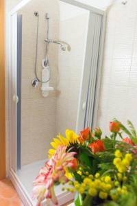 a mirror with a bouquet of flowers in a shower at Le Stanze Dell'Imperatore B&B in Melfi