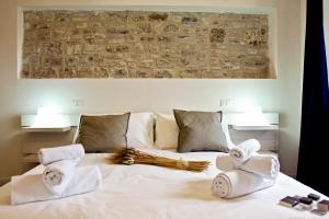 a bed with white pillows and pillows on top of it at Residence San Martino- Rooms & Suite Apartments in Erice