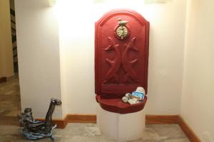 a red toilet in a room with a toy dinosaur at Panorama in Khrónia