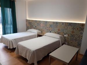 a room with two beds and a wall at Apartamentos El Castell in Benidorm