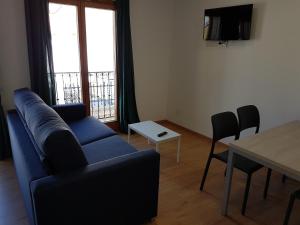 a living room with a blue couch and a table at Apartamentos El Castell in Benidorm