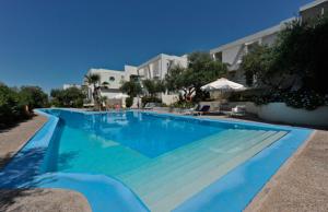 a large blue swimming pool in front of a building at Rodon Hotel in Chania