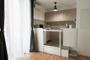 una piccola cucina con bancone bianco in una stanza di Sleep & Zupp Casa Olimpia a Napoli