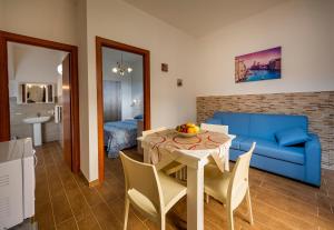 a living room with a table and a blue couch at Il Glicine Appartamenti & Rooms in Castellammare del Golfo