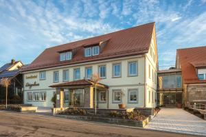 a large white building with a brown roof at Landhotel Steigenhaus in Untermünkheim