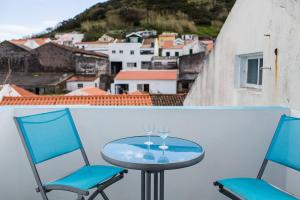 a table and two chairs on a balcony with a view at Casa de Hóspedes Porto Pim in Horta
