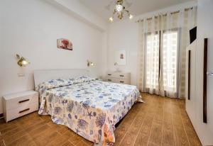 a bedroom with a bed and a dresser and a window at Il Glicine Appartamenti & Rooms in Castellammare del Golfo