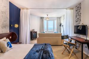 a hotel room with a bed and a couch at Baya Hotel in Capbreton