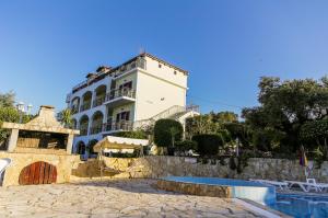 a white building next to a swimming pool at Seaview Apartments Tsilivi in Tsilivi