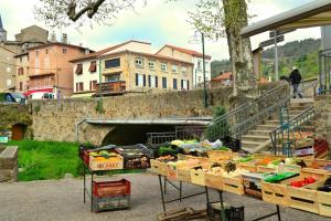a market with boxes of fruits and vegetables on display at La Mezzanine in Satillieu