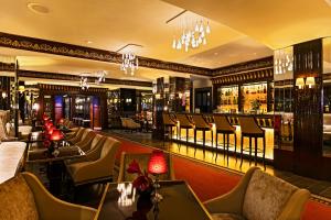 a restaurant with chairs and tables and a bar at Hôtel Barrière Le Majestic Cannes in Cannes