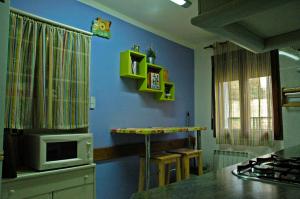 a kitchen with a microwave and a blue wall at Casa Lugaré in Ayerbe