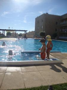 duas crianças estão de pé numa piscina em Apartment Labruge em Praia de Angeiras