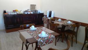 comedor con mesas y sillas y cocina en Hotel Fiss en Morro Redondo