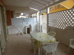 Zimmer mit einem Tisch und Stühlen sowie einer Küche in der Unterkunft Appartamenti Scala Dei Turchi Villa Saporito in Realmonte