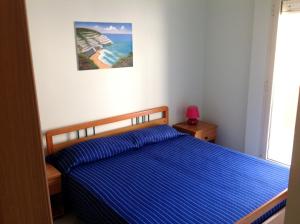 1 dormitorio con 1 cama y una foto en la pared en Appartamenti Scala Dei Turchi Villa Saporito, en Realmonte
