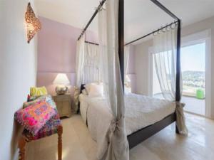 サンタ・エウラリア・デス・リウにあるFinca Rositaのベッドルーム(天蓋付きベッド1台、椅子付)