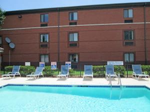a swimming pool with chairs and a building at Extended Stay America Suites - Dallas - Market Center in Dallas