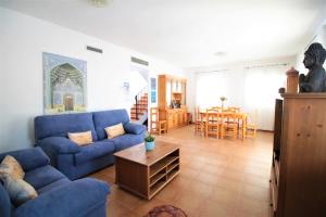 a living room with a blue couch and a table at Villa Sofia in San Antonio
