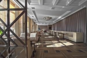 ロストフ・ナ・ドヌにあるRamada by Wyndham Rostov-on-Don Hotel and Spaのテーブルと椅子が備わるレストラン