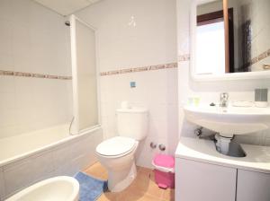 a white bathroom with a toilet and a sink at Villa Sofia in San Antonio