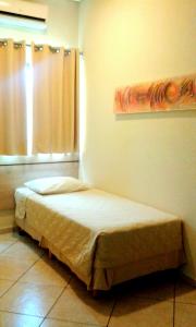 ein kleines Bett in einem Zimmer mit Fenster in der Unterkunft Hotel Eden in Sorocaba