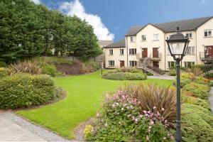 a house with a yard with a street light and flowers at Menlo Park Apartments in Galway