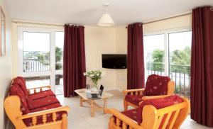 a living room with two chairs and a tv at Menlo Park Apartments in Galway