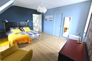 パンポルにあるGites du Portの青い壁のベッドルーム1室、黄色い毛布付きのベッド1台が備わります。