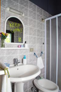 uma casa de banho com um lavatório branco e um espelho. em Lako Hostel em Capodimonte