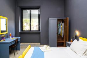 Schlafzimmer mit einem Bett, einem Schreibtisch und einem Fenster in der Unterkunft Lako Hostel in Capodimonte